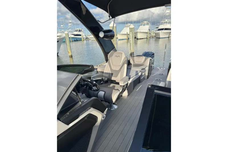 Slide: The Image of 2025 Avalon Excalibur Quad Lounge Windshield boat interior at marina, showcasing luxury seating. - 37