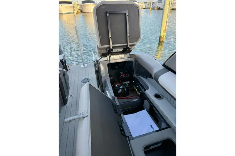 Slide: The Image of 2025 Avalon Excalibur Quad Lounge Windshield boat interior with open storage compartments. - 42