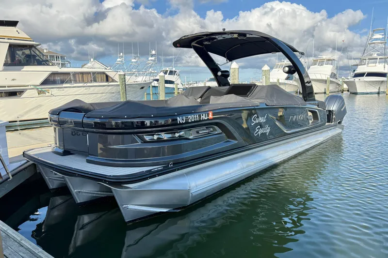 Slide: The Image of 2025 Avalon Excalibur Quad Lounge Windshield boat docked in marina, sleek design, luxury features. - 44