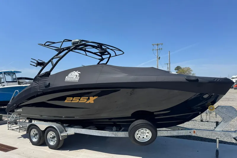 Slide: The Image of 2026 Yamaha Boats 255XD on trailer, covered, with sleek black design. - 14