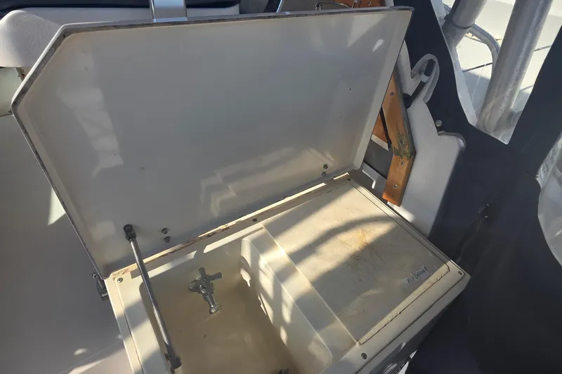 Slide: The Image of Open storage compartment on 1990 Grady-White Marlin 280 boat, featuring a faucet inside. - 21