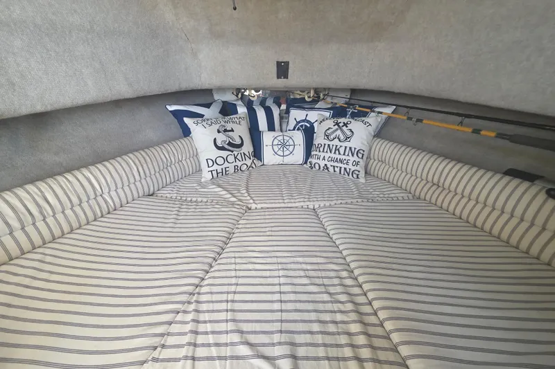 Slide: The Image of Cozy cabin interior of 1990 Grady-White Marlin 280 with nautical-themed pillows and striped bedding. - 22