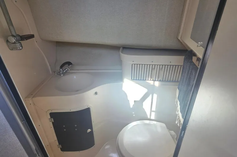 Slide: The Image of 1990 Grady-White Marlin 280 boat bathroom with sink, toilet, and storage cabinet. - 24