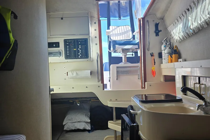 Slide: The Image of Interior of a 1990 Grady-White Marlin 280 boat, featuring a compact cabin space. - 3