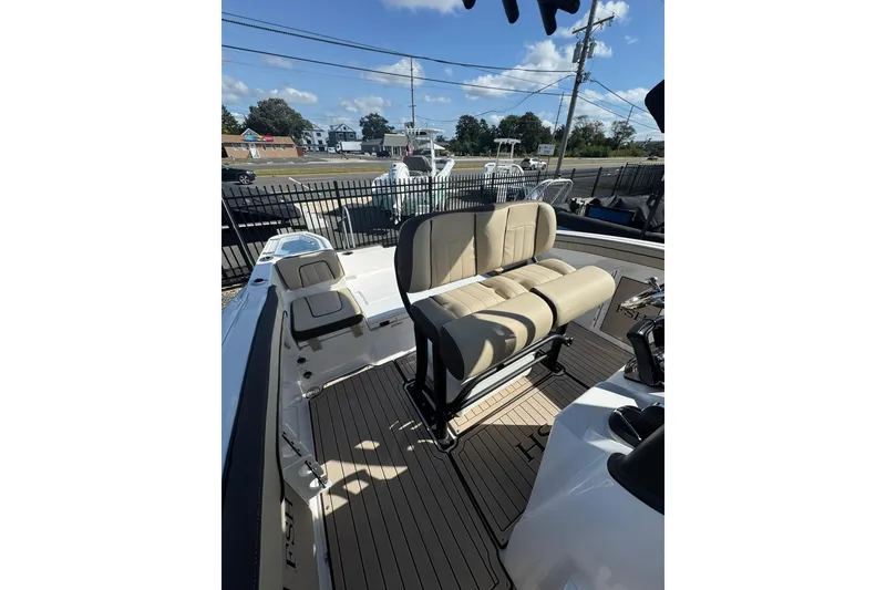 Slide: The Image of 2026 Yamaha Boats 255 FSH Sport H interior with open storage compartments and seating. - 13