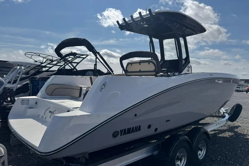 Slide: The Image of 2026 Yamaha Boats 255 FSH Sport H on trailer, displayed outdoors under clear sky. - 2