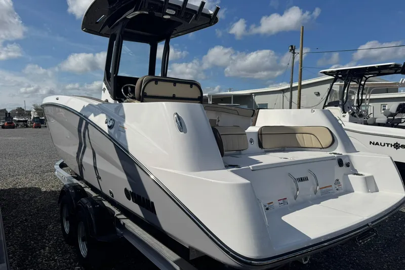 Slide: The Image of 2026 Yamaha Boats 255 FSH Sport H on trailer, covered, under blue sky. - 5