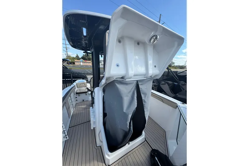 Slide: The Image of 2026 Yamaha Boats 255 FSH Sport H, sleek white design, parked on a trailer under blue skies. - 6