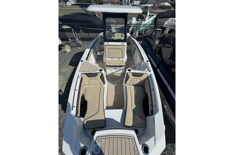 Slide: The Image of 2026 Yamaha Boats 255 FSH Sport H interior with seating and console, docked outdoors. - 8