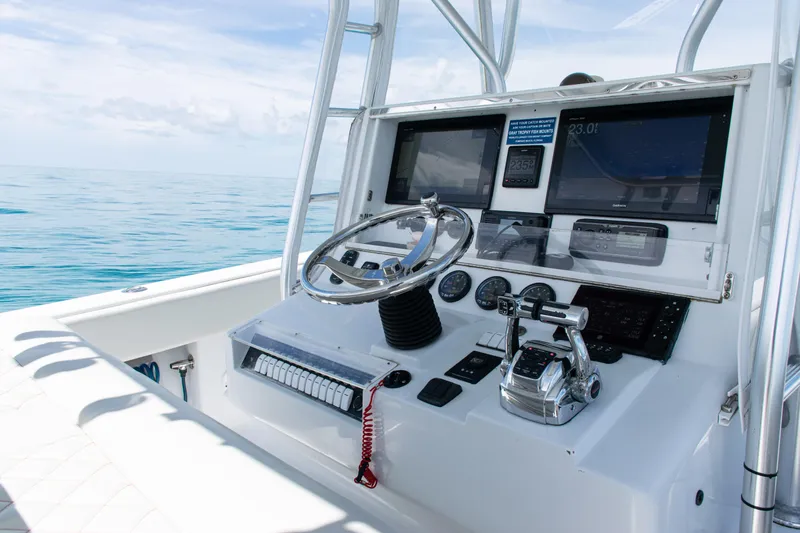 Slide: The Image of 2006 SeaVee 340B boat dashboard with steering wheel and navigation screens on open water. - 18