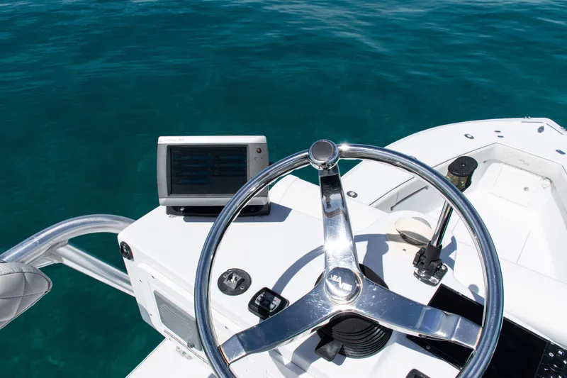 Slide: The Image of Steering wheel and controls of a 2006 SeaVee 340B boat on clear blue water. - 38