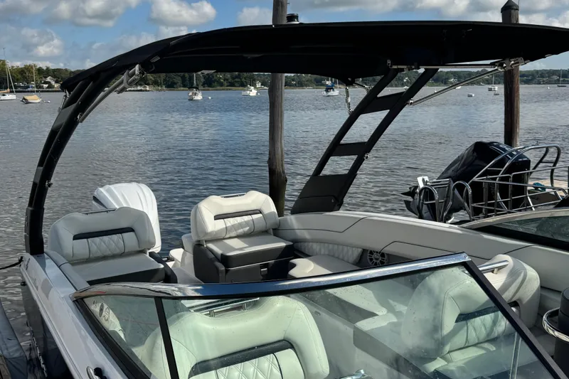 Slide: The Image of 2024 Regal LX6 boat with sleek design, docked by a scenic lake. - 10