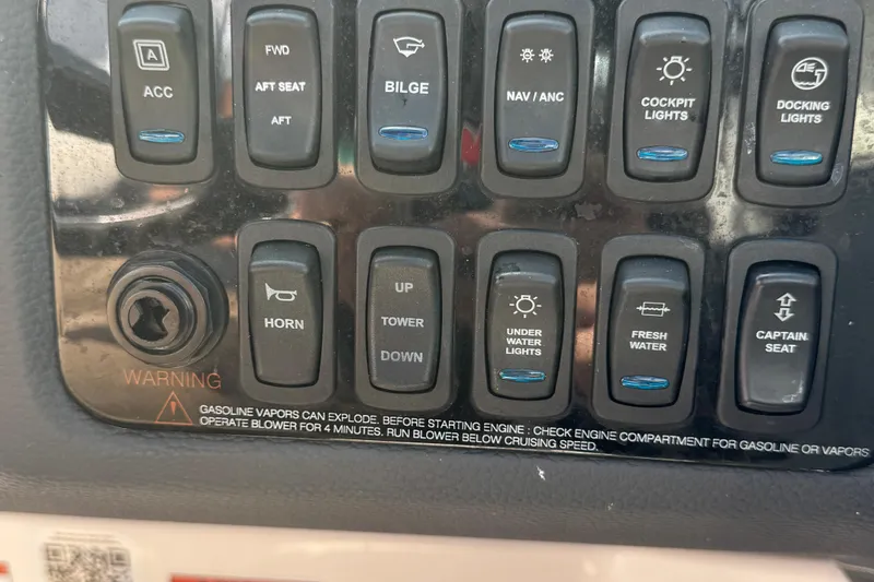 Slide: The Image of Control panel of a 2024 Regal LX6 boat with various switches and warning label. - 15