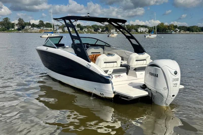 Slide: The Image of 2024 Regal LX6 boat with Yamaha 300 V6 engine on calm water. - 2