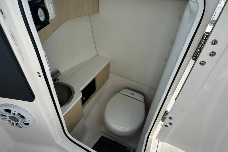 Slide: The Image of 2024 Regal LX6 boat interior bathroom with toilet and sink. - 20