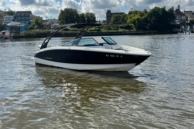 Slide: The Image of 2024 Regal LX6 boat on a calm river with scenic background. - 5