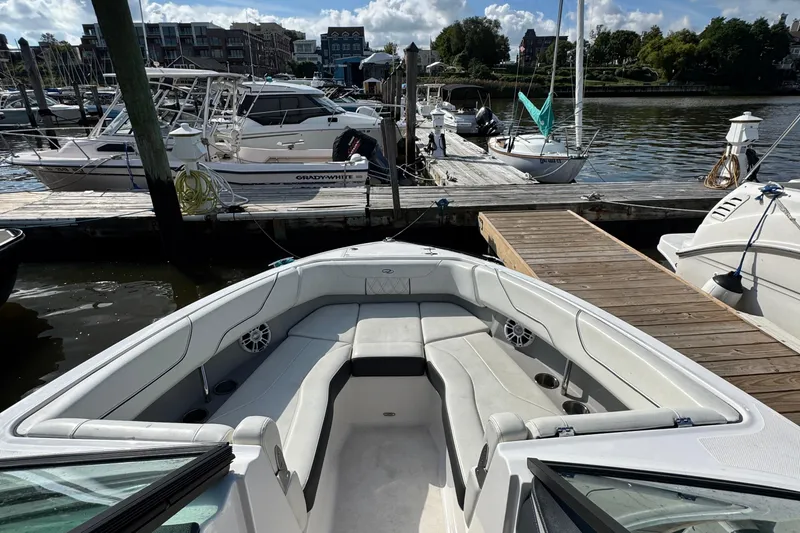 Slide: The Image of 2024 Regal LX6 boat docked at marina, featuring spacious seating and modern design. - 9