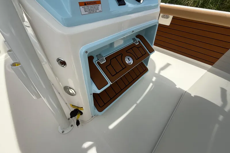 Slide: The Image of 2026 Pathfinder 2400 TRS boat console with open storage compartment and wood accents. - 30