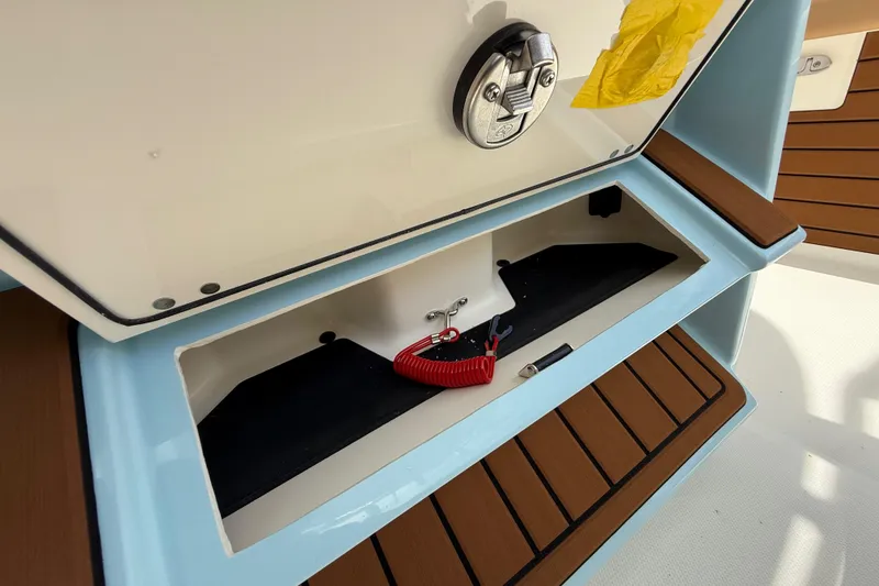 Slide: The Image of Pathfinder 2400 TRS 2026 boat storage compartment with latch and red safety cord. - 31