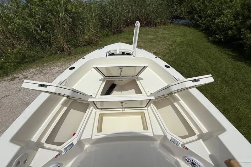 Slide: The Image of 2026 Pathfinder 2400 TRS boat with open storage compartments, grassy background. - 36