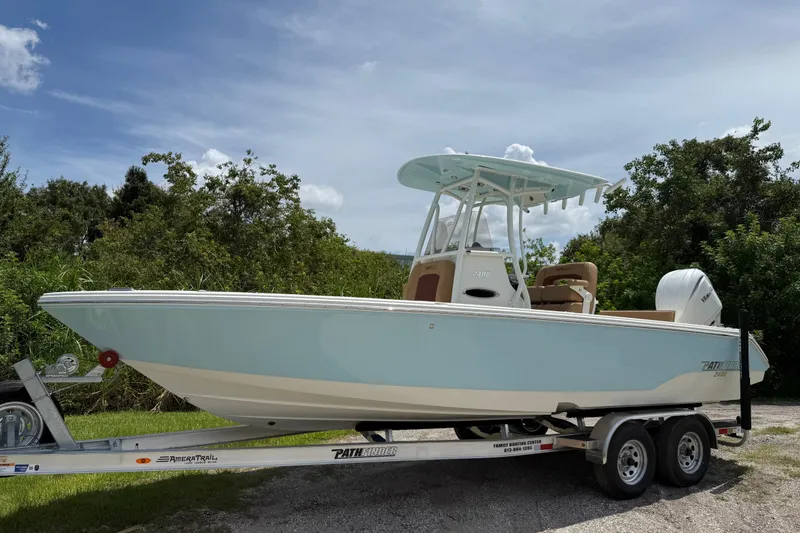 Slide: The Image of 2026 Pathfinder 2400 TRS boat on trailer, parked outdoors with lush greenery. - 9