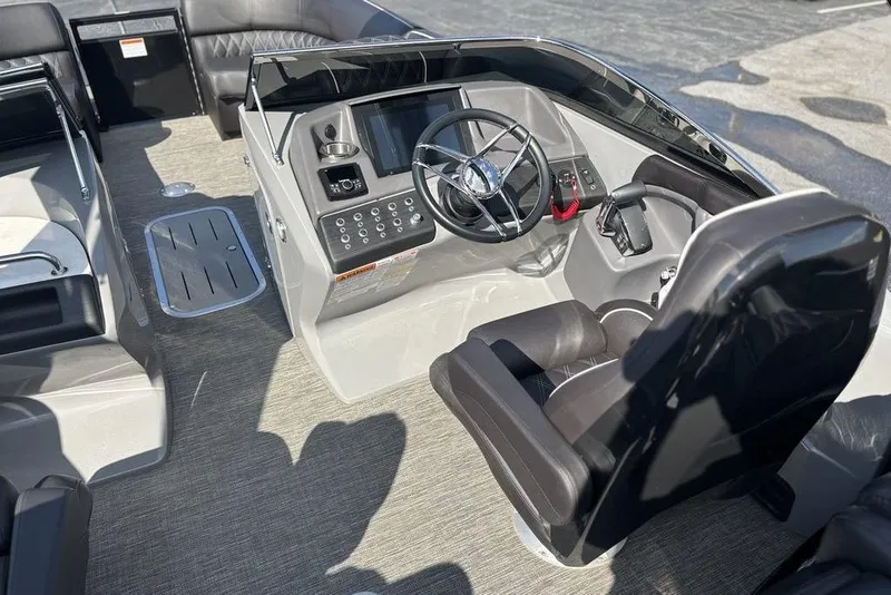 Slide: The Image of 2024 Bennington 25 QFBWA boat interior with steering wheel and seating. - 12