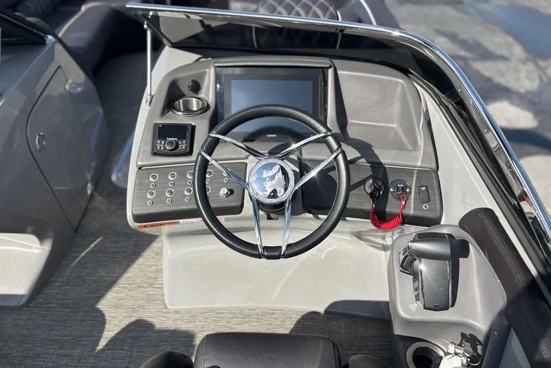 Slide: The Image of 2024 Bennington 25 QFBWA boat dashboard with steering wheel and control panel. - 22