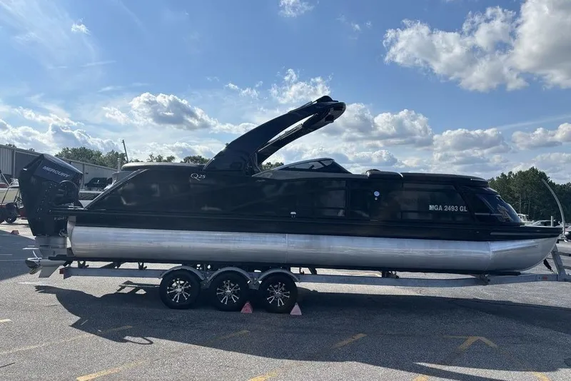 Slide: The Image of 2024 Bennington 25 QFBWA pontoon boat on trailer under a blue sky. - 8