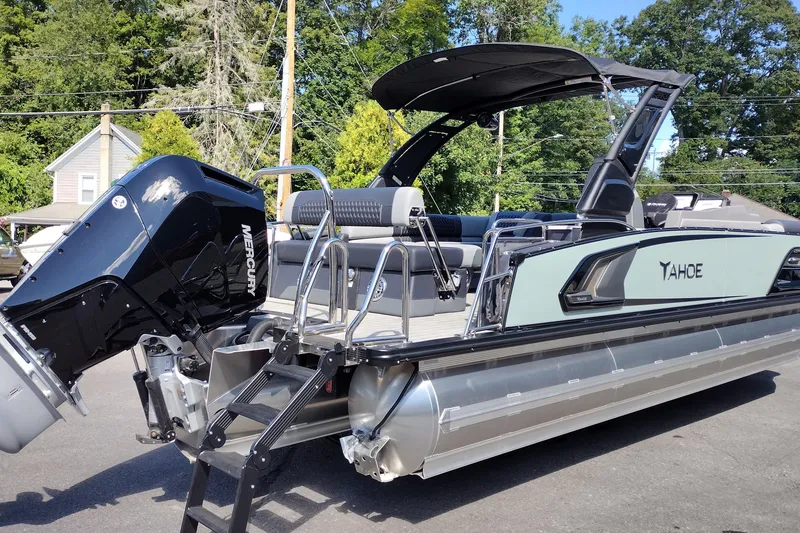 Slide: The Image of 2026 Tahoe Pontoon Grand Tahoe LTD Cruise Rear Bench with Mercury engine, parked outdoors. - 51
