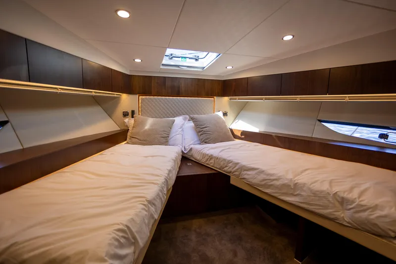 Slide: The Image of Luxurious twin cabin interior of 2025 Fairline Squadron 50 yacht, featuring elegant wood finishes. - 23