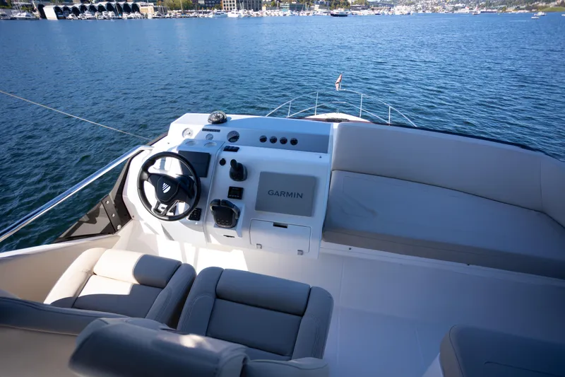 Slide: The Image of 2025 Fairline Squadron 50 yacht helm with Garmin navigation, overlooking serene waters. - 29