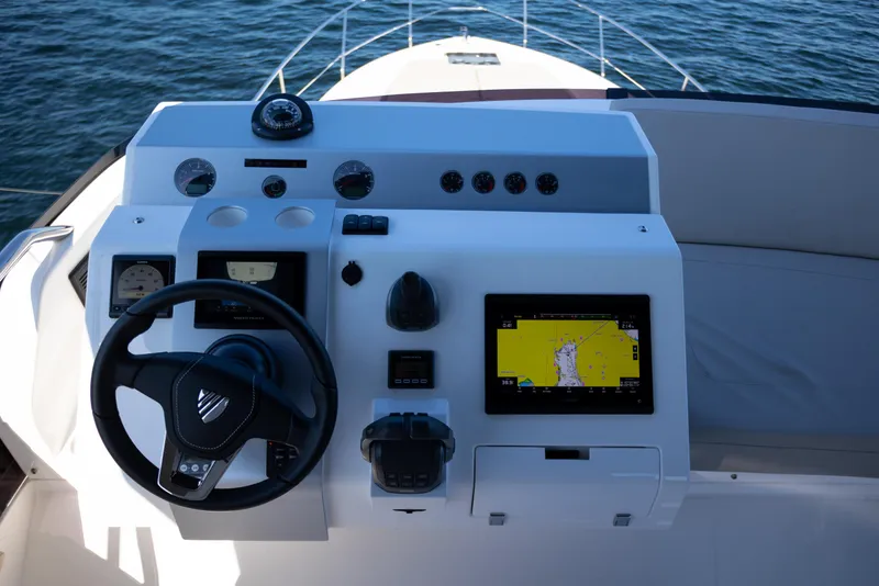 Slide: The Image of 2025 Fairline Squadron 50 yacht helm with navigation display and steering wheel. - 30