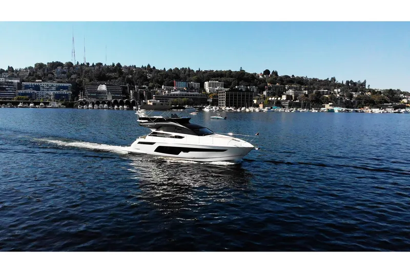 Slide: The Image of 2025 Fairline Squadron 50 yacht cruising on a scenic waterfront with city skyline. - 39