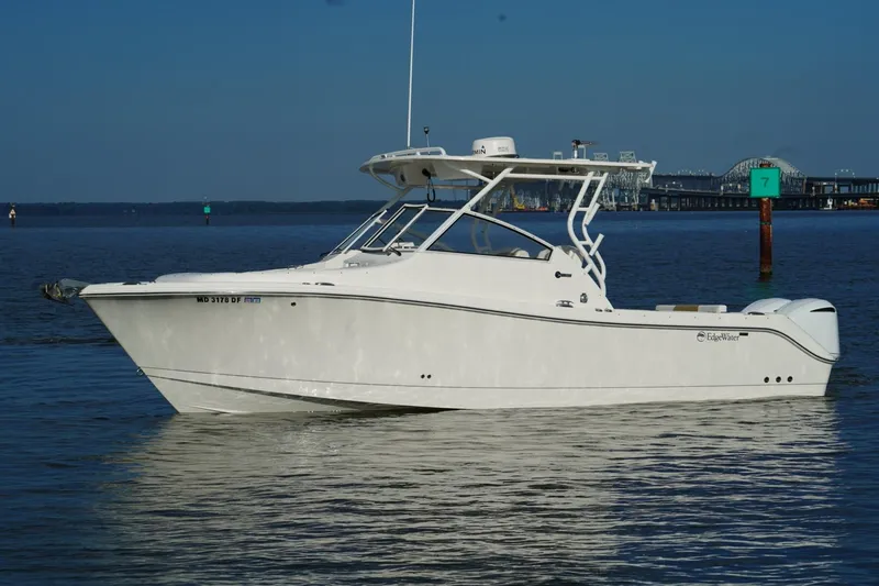 Slide: The Image of 2016 Edgewater 280 CX boat on calm water with a bridge in the background. - 0