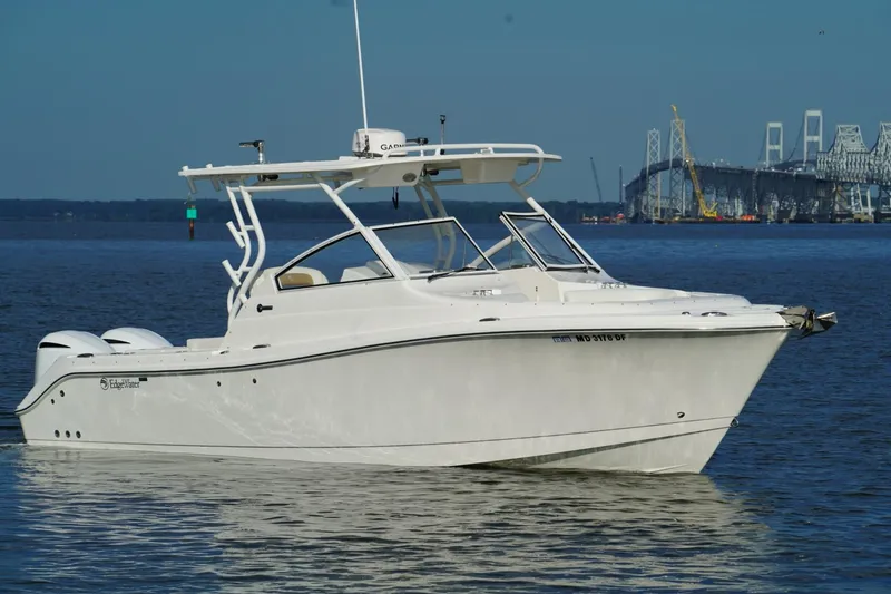Slide: The Image of 2016 Edgewater 280 CX boat on water near a bridge, clear blue sky. - 1