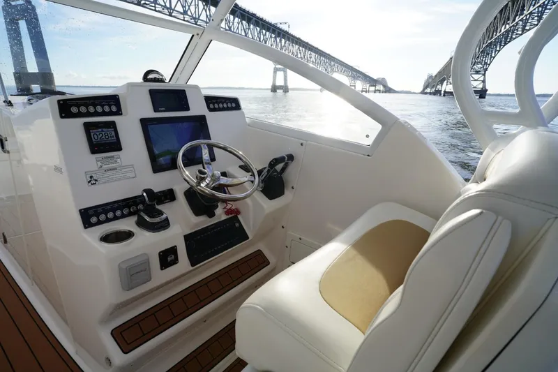 Slide: The Image of Helm of 2016 Edgewater 280 CX boat with bridge view in background. - 12