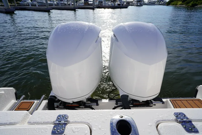 Slide: The Image of Twin outboard engines on a 2016 Edgewater 280 CX boat at a marina. - 14