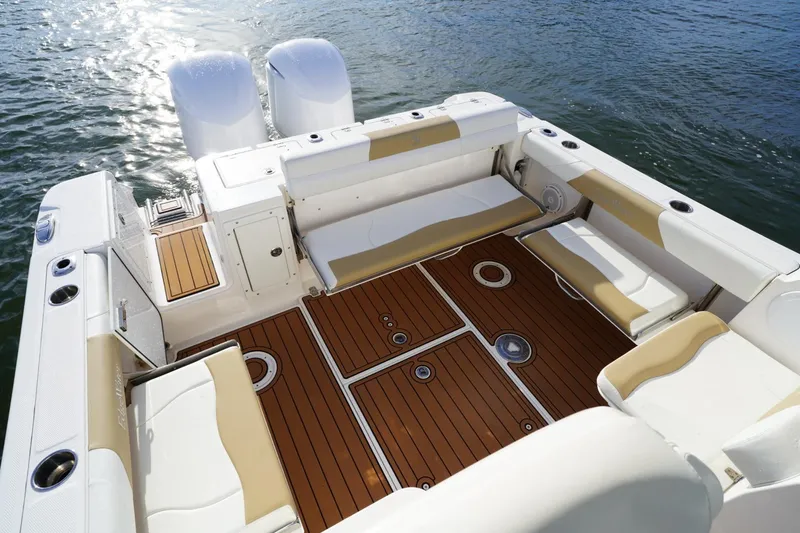 Slide: The Image of 2016 Edgewater 280 CX boat interior with teak flooring and cushioned seating. - 15