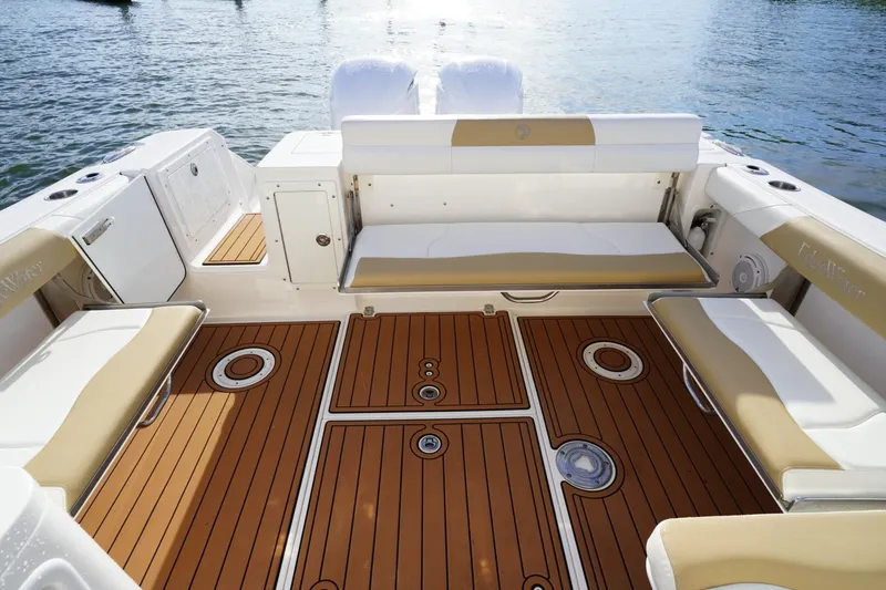 Slide: The Image of 2016 Edgewater 280 CX boat interior with teak flooring and cushioned seating. - 16