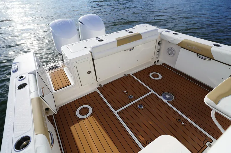 Slide: The Image of 2016 Edgewater 280 CX boat deck with teak flooring and dual engines on water. - 18