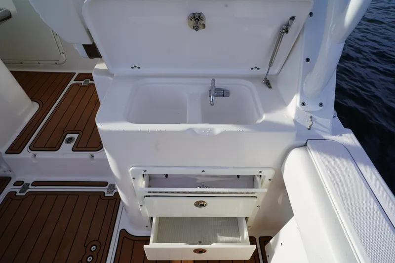 Slide: The Image of Edgewater 280 CX 2016 boat interior with sink and storage drawers. - 21