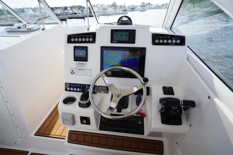 Slide: The Image of Helm of 2016 Edgewater 280 CX boat with navigation instruments and steering wheel. - 22