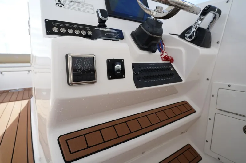 Slide: The Image of Control panel of a 2016 Edgewater 280 CX boat with steering wheel and switches. - 26