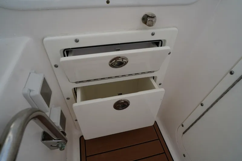 Slide: The Image of Storage compartments on a 2016 Edgewater 280 CX boat, featuring two open drawers. - 28