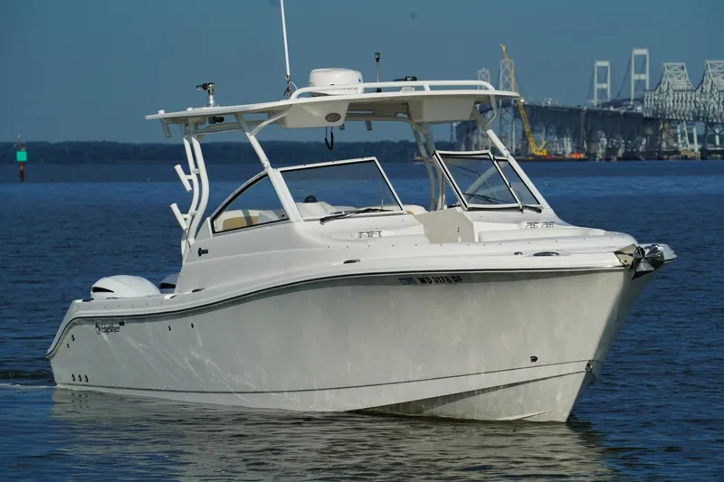 Slide: The Image of 2016 Edgewater 280 CX boat cruising on water near a bridge. - 3