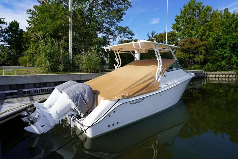 Slide: The Image of 2016 Edgewater 280 CX boat docked, covered, with Yamaha engines, surrounded by greenery. - 31
