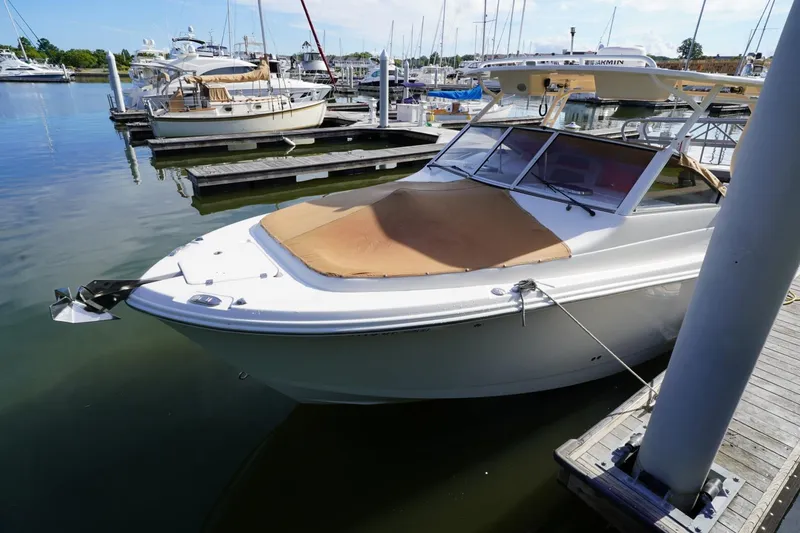 Slide: The Image of 2016 Edgewater 280 CX boat docked at a marina, featuring a covered bow. - 33