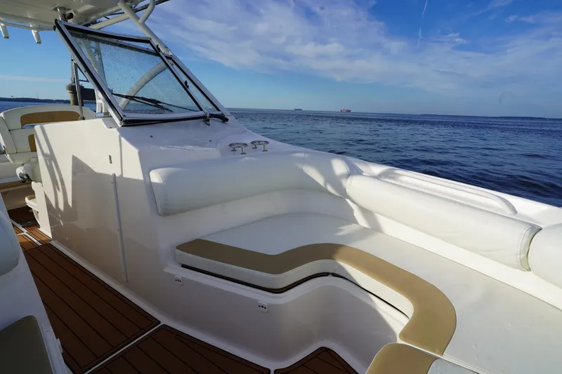 Slide: The Image of 2016 Edgewater 280 CX boat interior with seating, ocean view, and clear sky. - 8