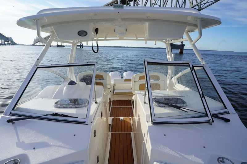 Slide: The Image of 2016 Edgewater 280 CX boat on water, featuring open deck and windshield. - 9