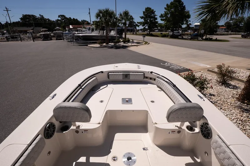 Slide: The Image of 2026 Carolina Skiff 22 Ultra Elite boat interior with seating and speakers, parked outdoors. - 13